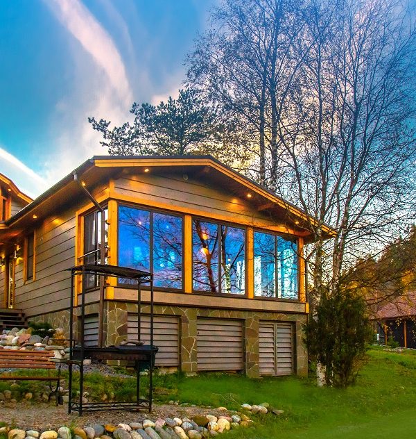 Cottage on the slope. Cottage village. House with large windows. The construction of the mysterious houses. Infrastructure. Living in the country. Wooden house.